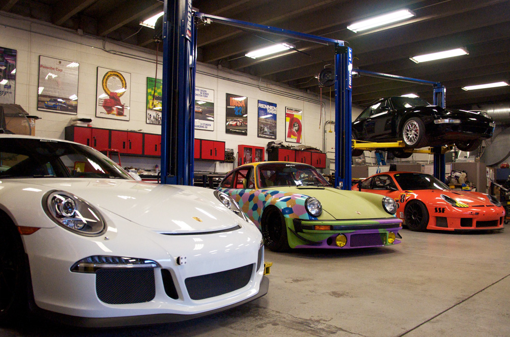 Porsches staged inside the Lüfteknic shop, including 991 GT3, projectstuka, 993 turbo and orange Hazardous Sports 996 GT3 RS