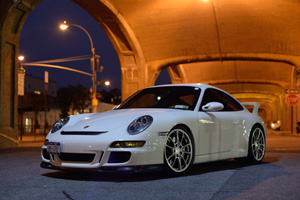 A white 997 GT3 under a bridge at night