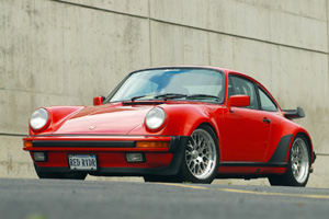 A red 930 turbo sits in a parking lot