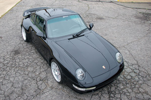 A Black 993 Porsche 911 Turbo view from above as it sits in a parking lot.