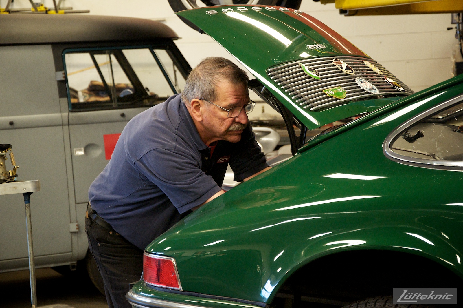 A Lufteknic employee working on the engine in a green Porsche 912.