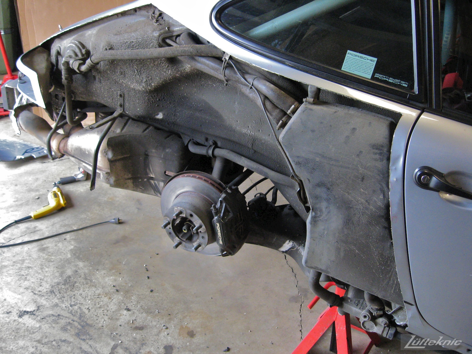 A cut away rear quarter panel showing the suspension and exhaust on the 964 RS America project