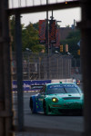 The iconic teal and blue Falken Tire Porsche 911 RSR at Baltimore with Orioles banners by the stadium.