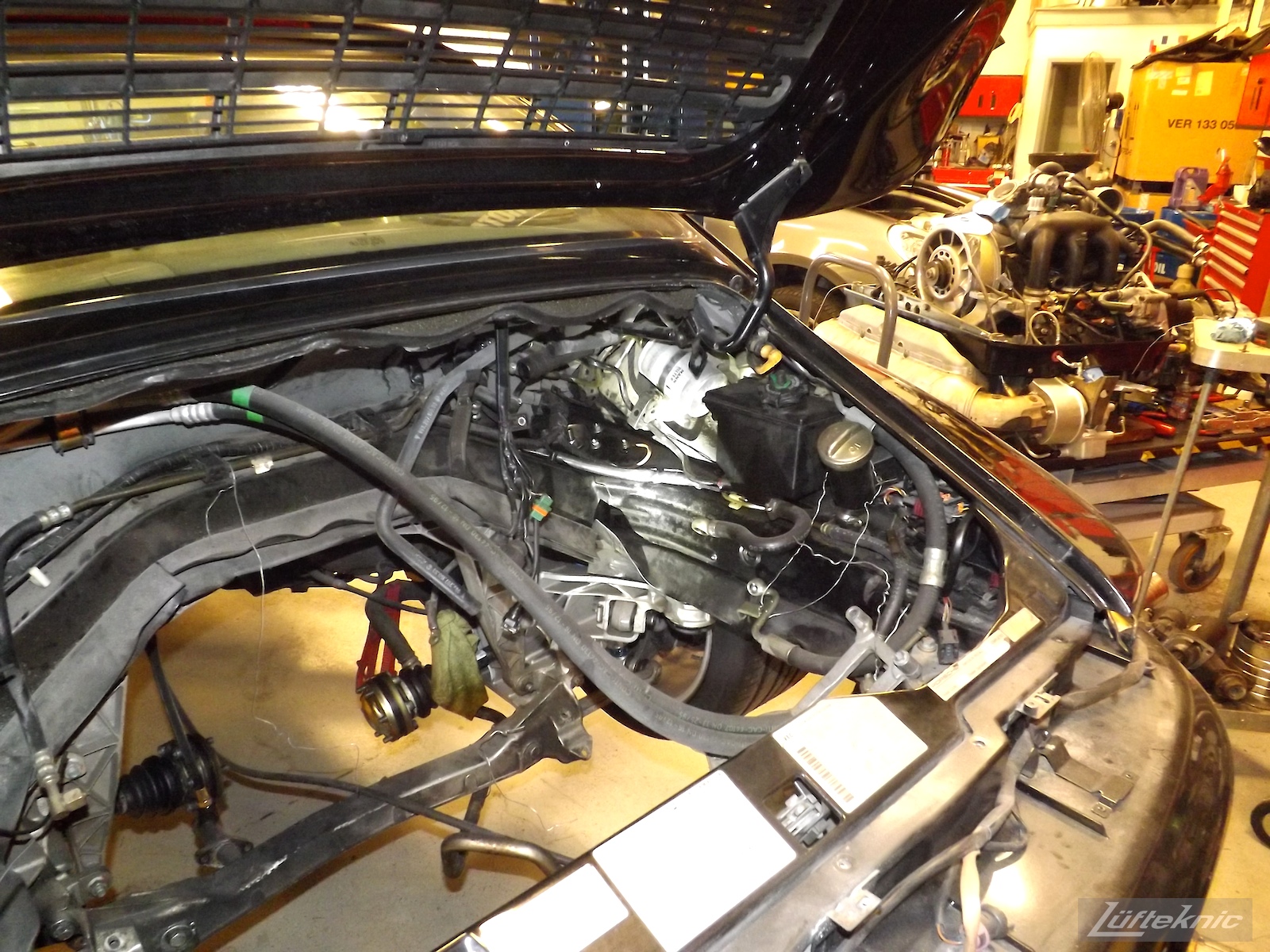 993 Turbo car on a lift with the engine staged on a table to be reinstalled.