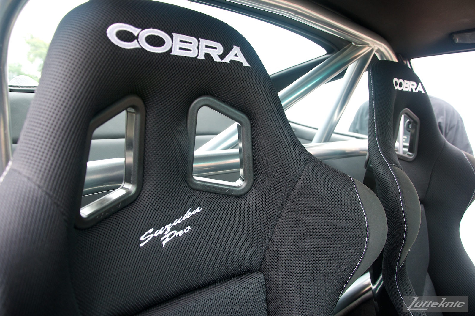 Cobra seats and roll bar mounted in a black 993 Porsche Turbo.