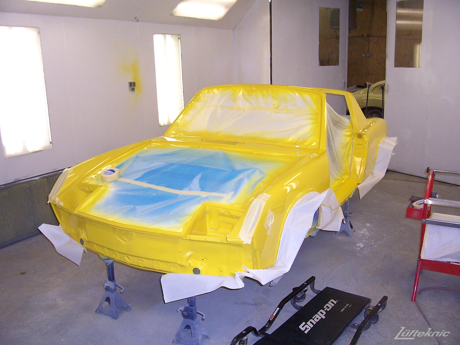 Fresh yellow paint on a Porsche 914 being restored.