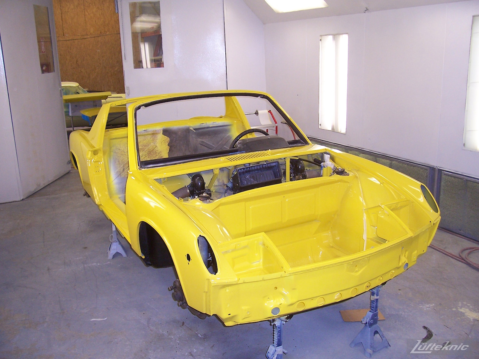 Fresh yellow paint on a Porsche 914 being restored.