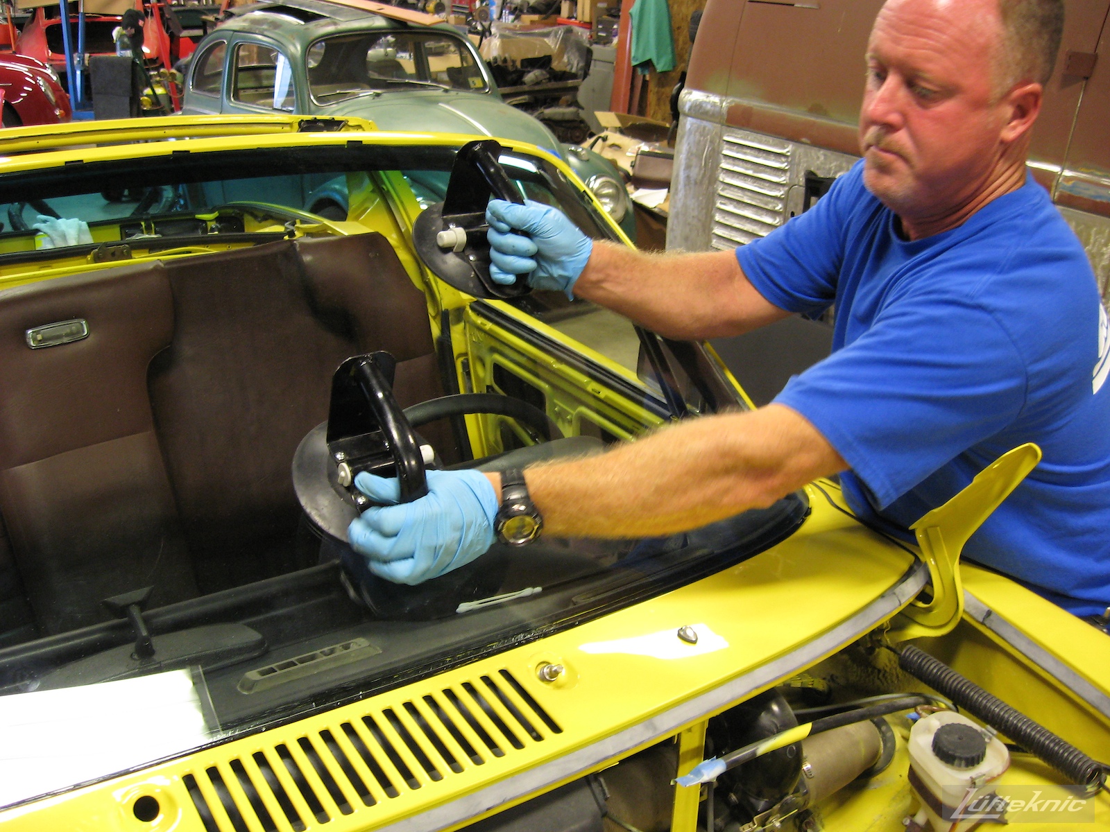 Installing the windshield into a restored yellow Porsche 914 at Lufteknic.