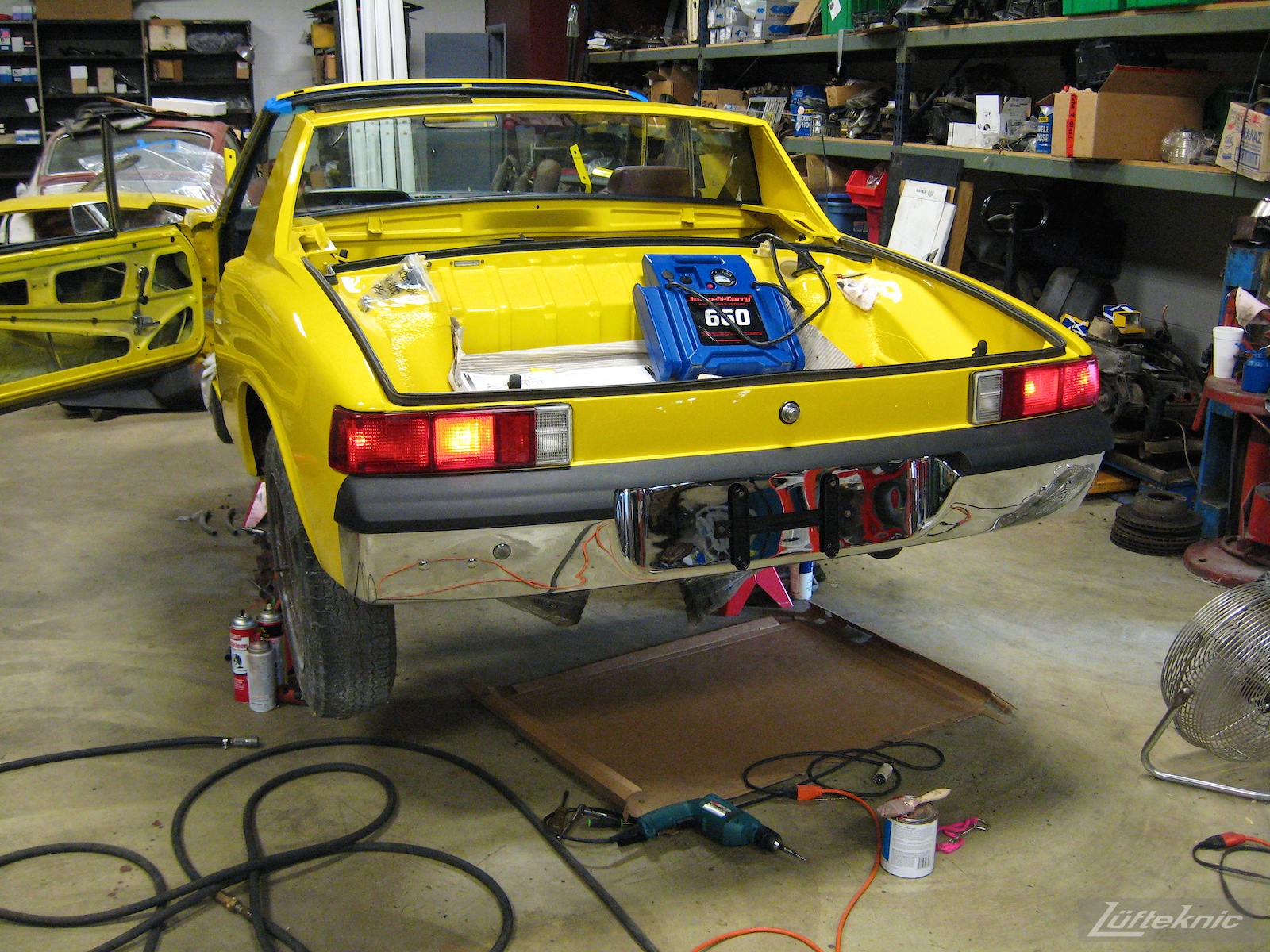 Illuminated rear tail lights on a restored yellow Porsche 914 at Lufteknic.