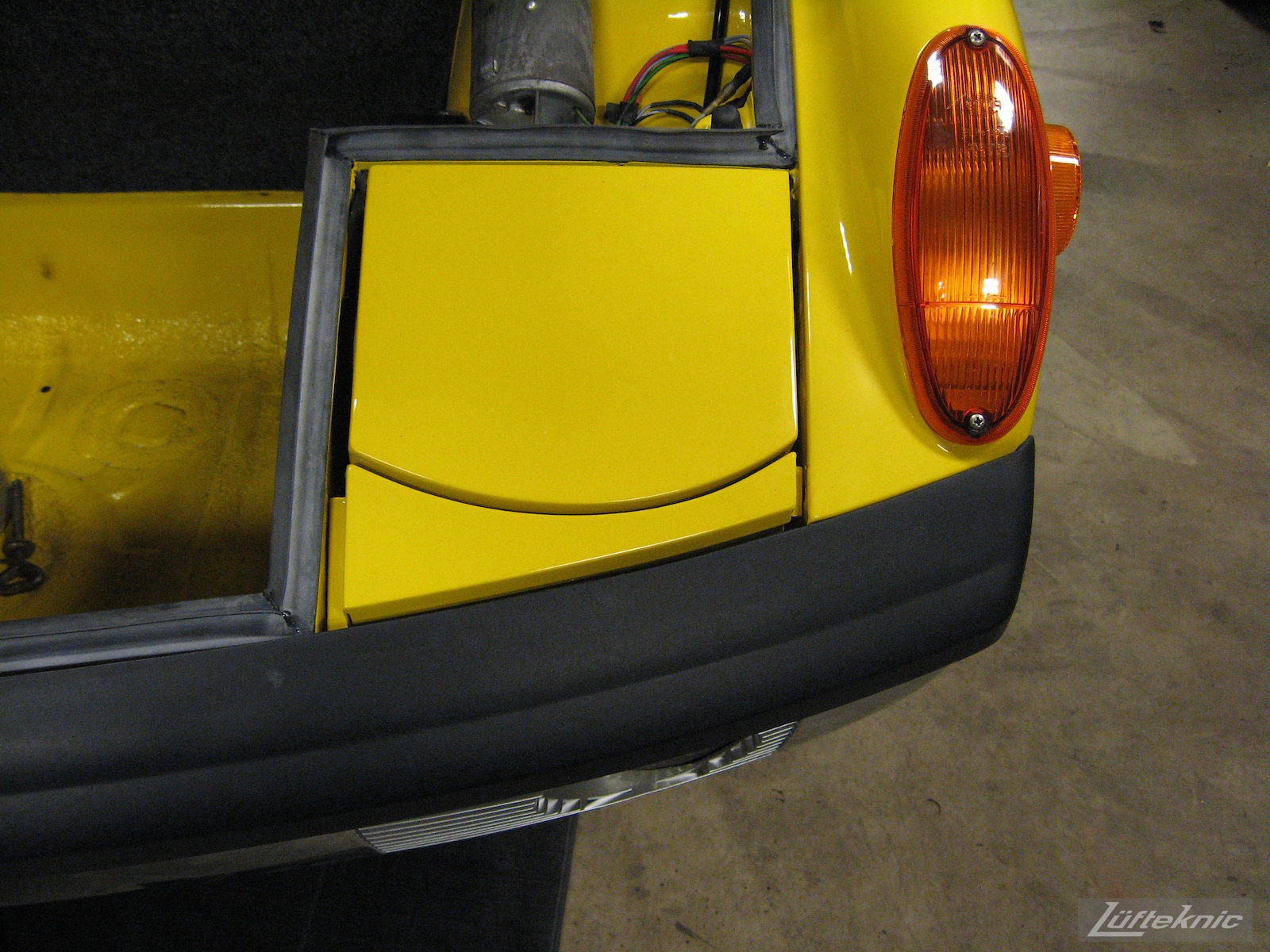 Front bumper and lighting details on a restored yellow Porsche 914 at Lufteknic.