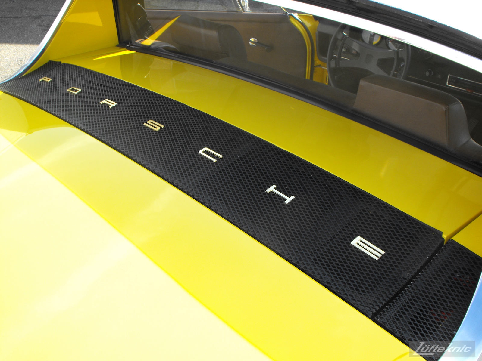Engine deck lid details on a completely restored yellow Porsche 914 posing in the parking lot of Lufteknic.