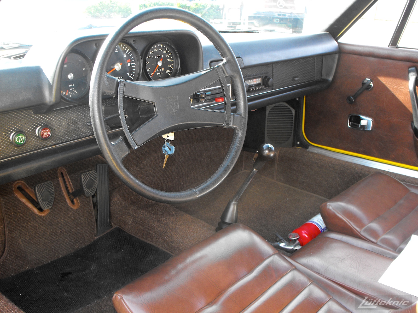 The all original interior of a completely restored yellow Porsche 914 posing in the parking lot of Lufteknic.