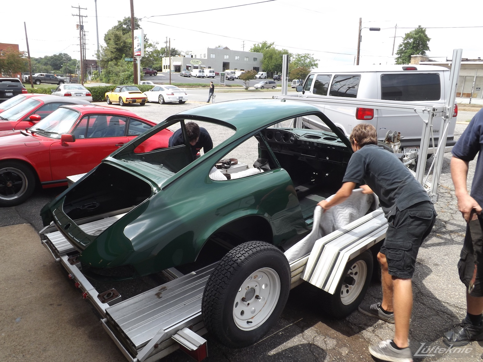 Unloading the freshly painted body shell of an Irish Green Porsche 912 undergoing restoration at Lufteknic.