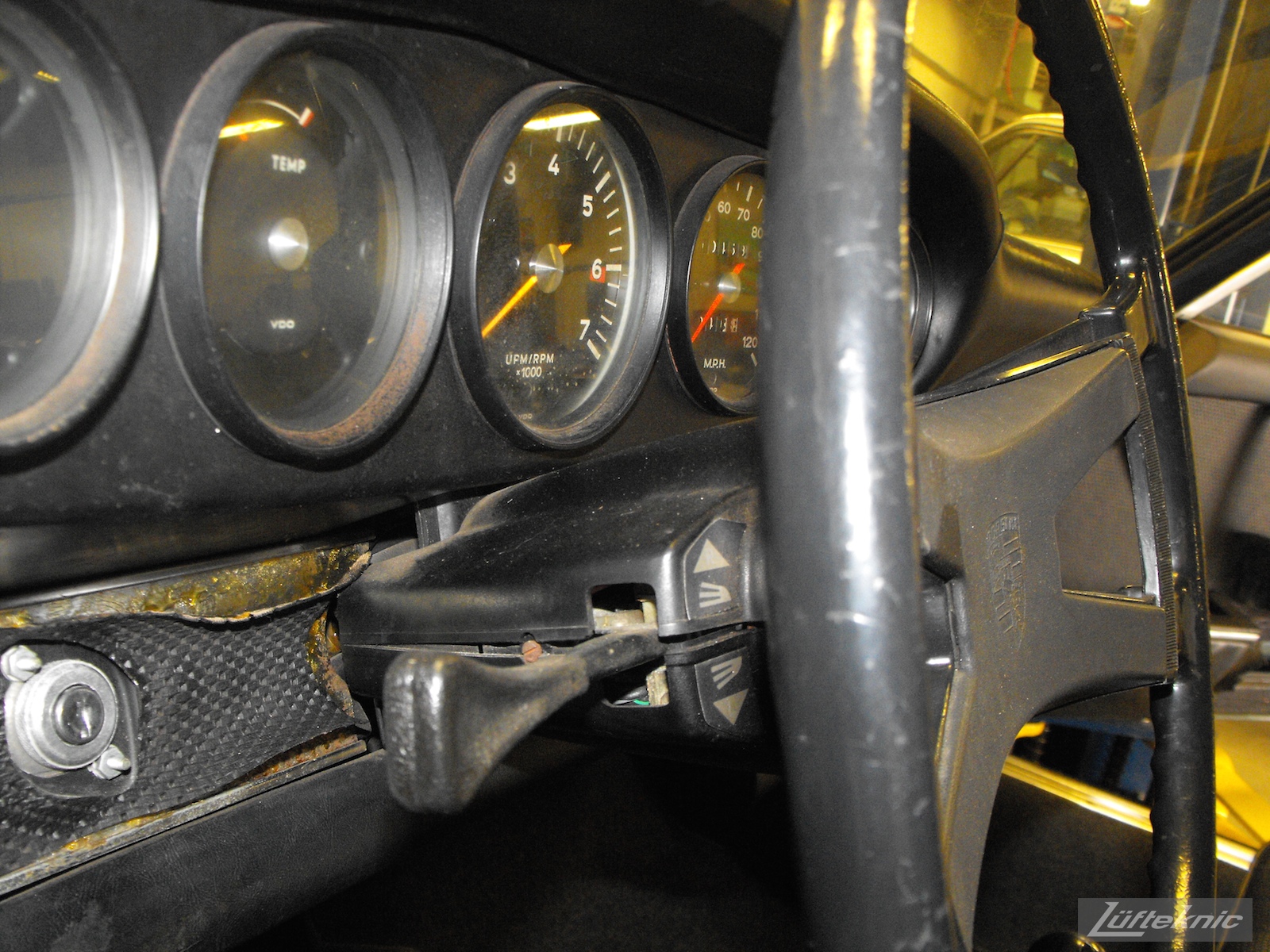 Worn dash and gauge components shown of an Irish Green Porsche 912 undergoing restoration at Lufteknic.