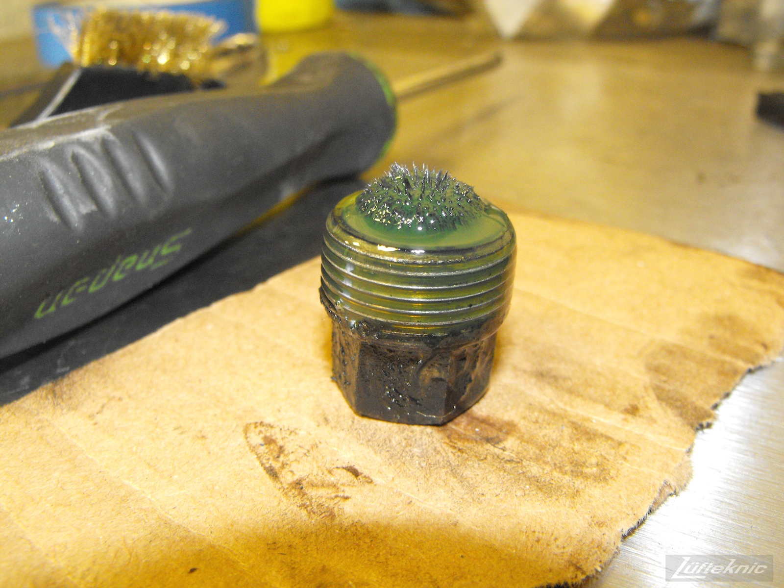 A magnetic oil drain plug showing significant metal shavings from an Irish Green Porsche 912 undergoing restoration at Lufteknic.