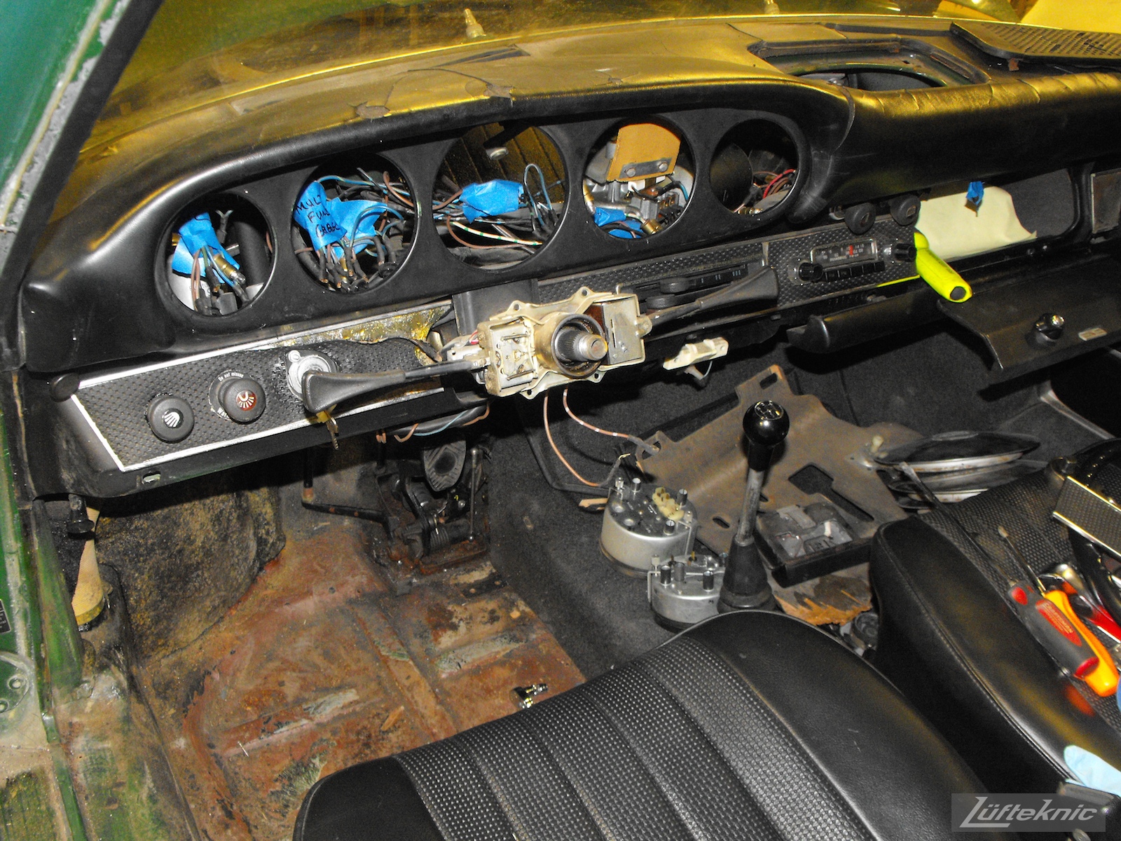 Stripped down dashboard and interior of an Irish Green Porsche 912 undergoing restoration at Lufteknic.