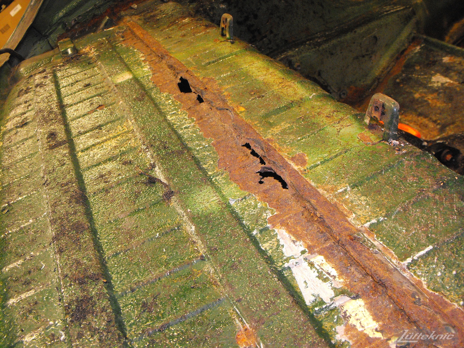 Rear decklid rust shown on an Irish Green Porsche 912 undergoing restoration at Lufteknic.