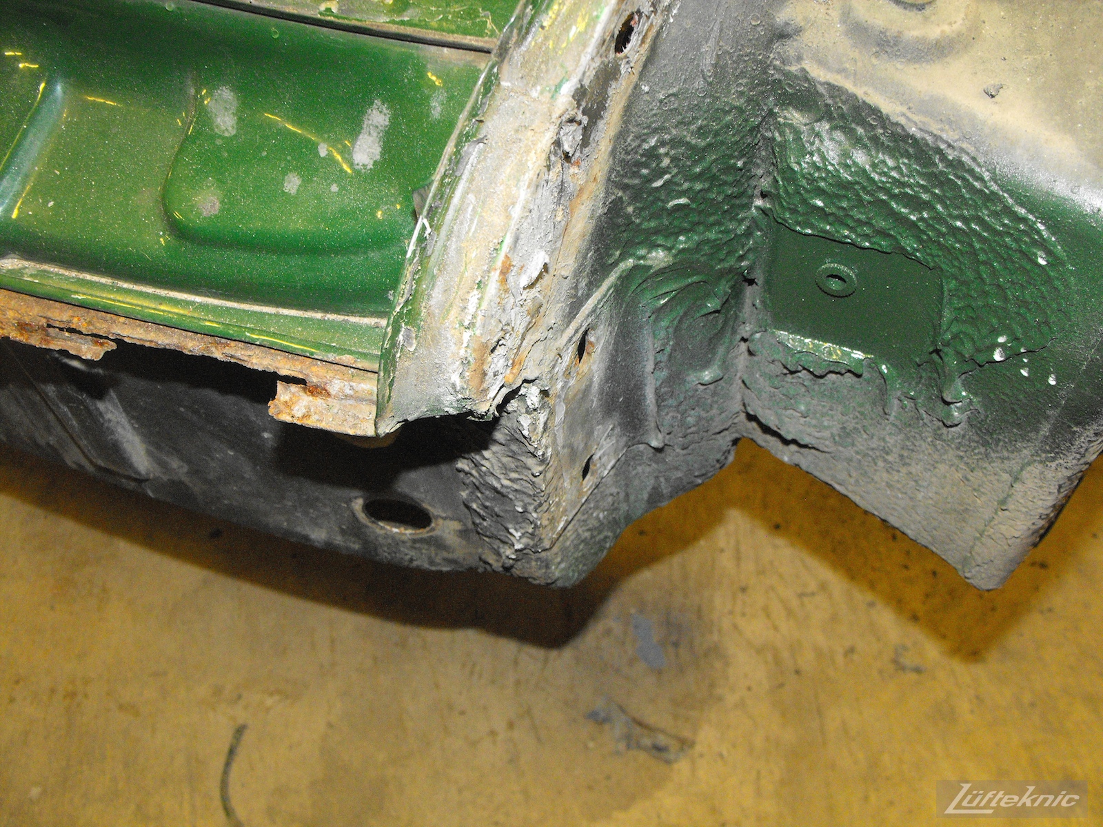 Front pan damage on an Irish Green Porsche 912 undergoing restoration at Lufteknic.