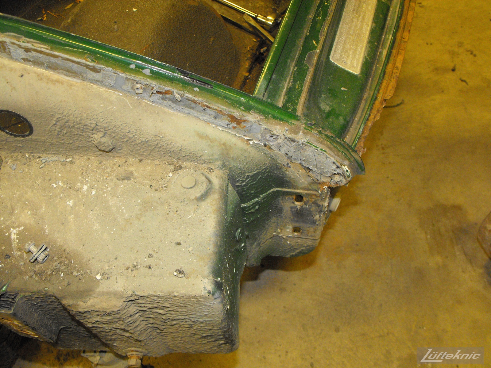Front chassis wear and some rust on an Irish Green Porsche 912 undergoing restoration at Lufteknic.