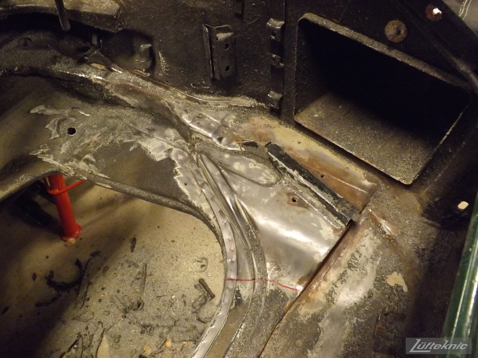 Front pan repair from battery acid and rust damage on an Irish Green Porsche 912 undergoing restoration at Lufteknic.