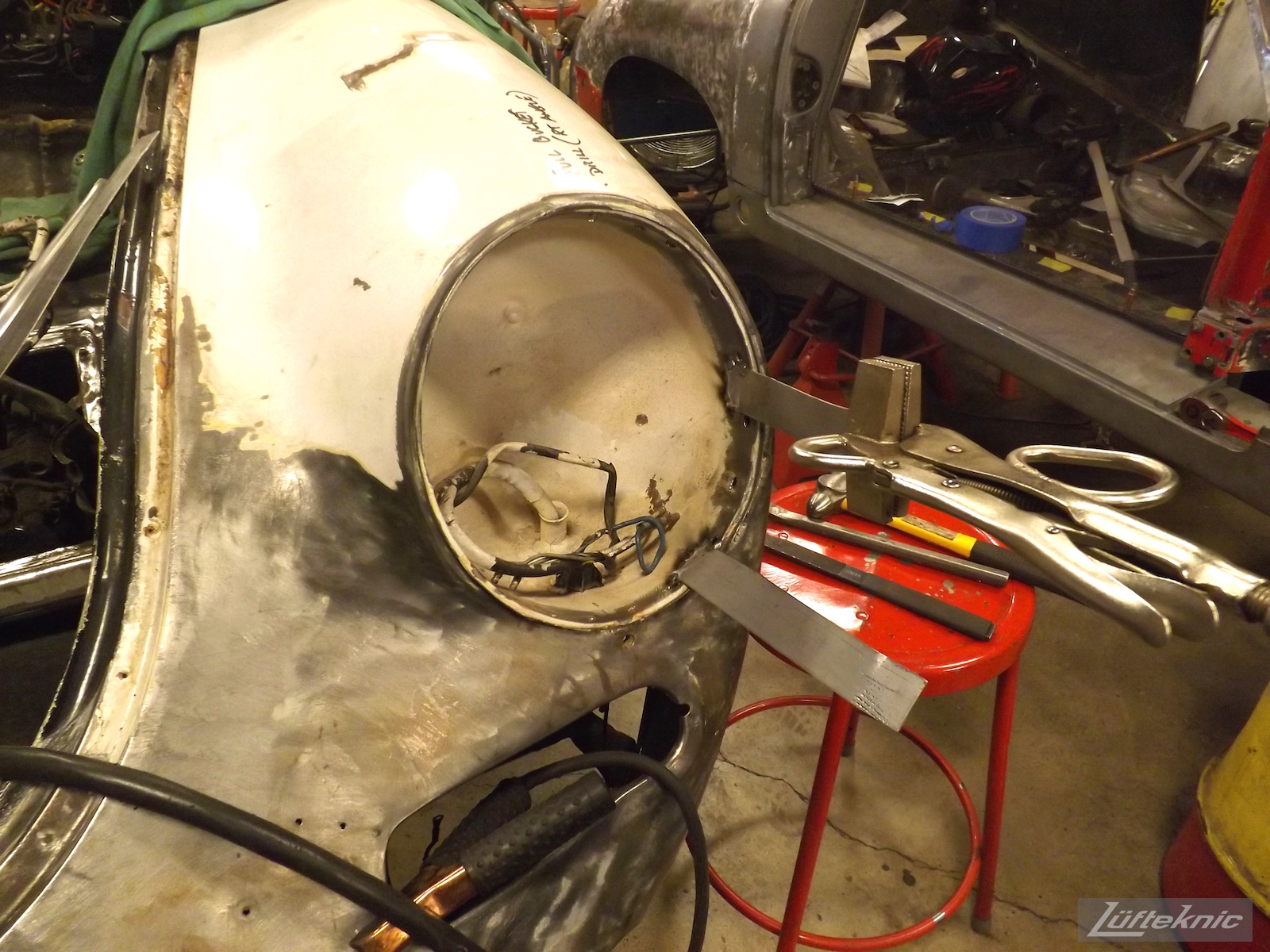 Headlight bucket adjustment on a White 1964 Porsche 356SC being restored.
