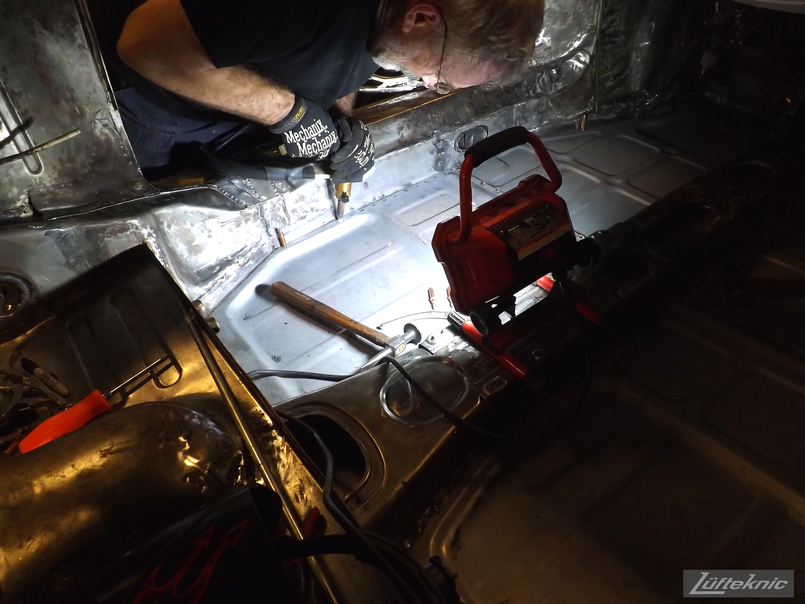 Spot welding the floor of a White 1964 Porsche 356SC being restored.